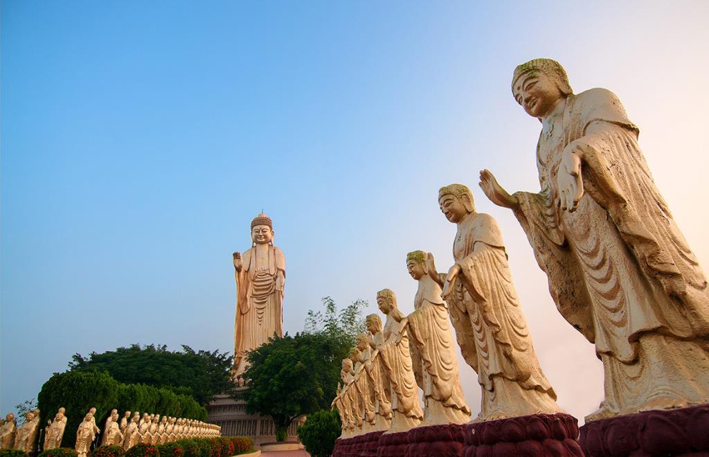 Large Buddha statue with several smaller statues around it